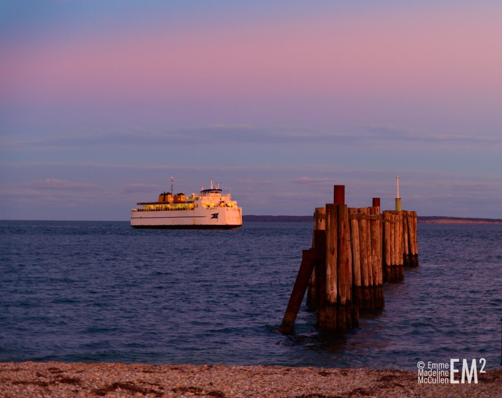 A ferry approaching pilings at dusk